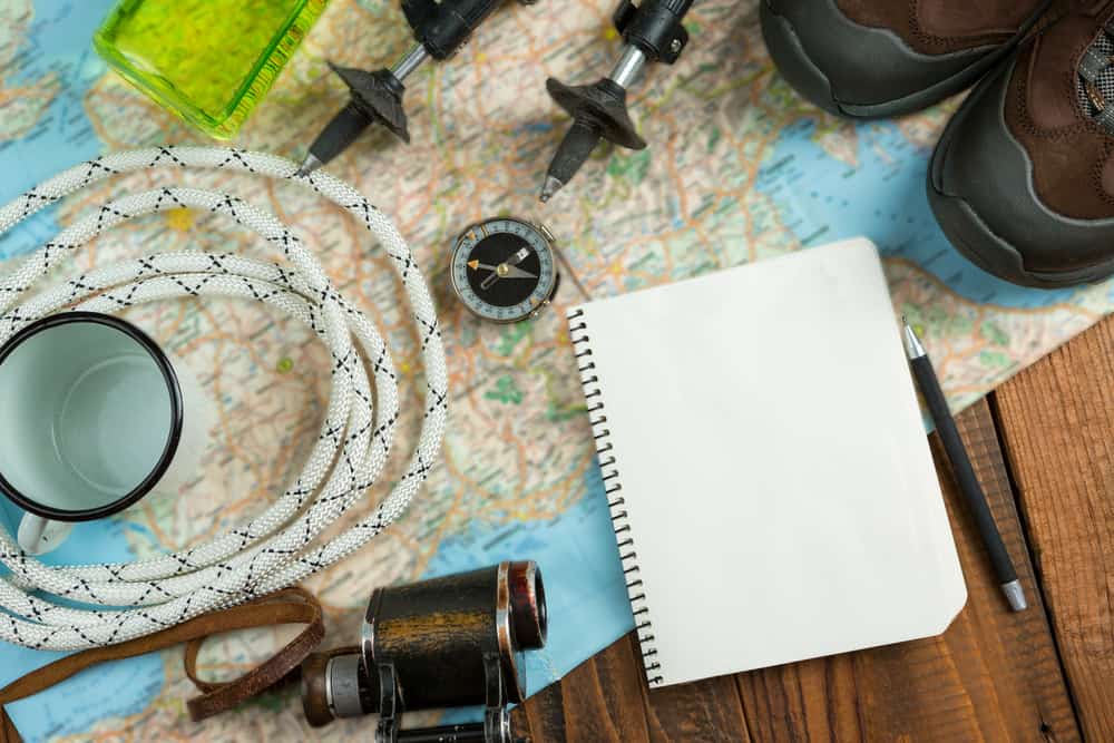 camping gear and notebook on a table